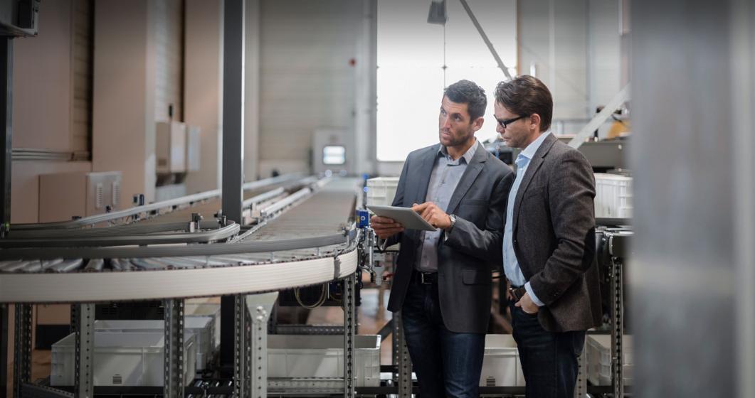 Two men inspect an automation facility